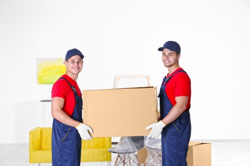 Local movers carrying furniture through a Wapping residential street
